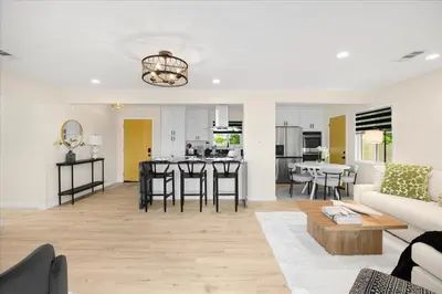a living room and kitchen with a couch and a table at Luxurious Newly Remodeled 4 Bedroom Home with Large Backyard near Disneyland in Anaheim
