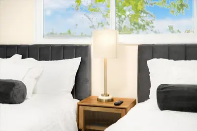 a bedroom with two beds and a lamp on a night stand at Luxurious Newly Remodeled 4 Bedroom Home with Large Backyard near Disneyland in Anaheim