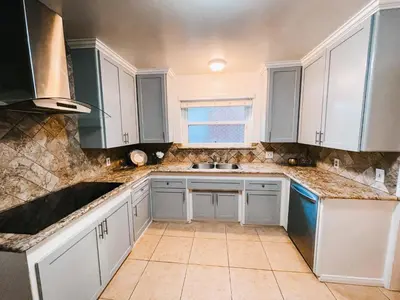 a kitchen with white cabinets and a sink at Lovely home close by SOFI Stadium in Inglewood