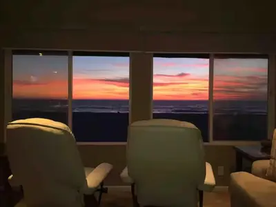 two chairs in a room with a view of a sunset at 90210 Beach House Middle Unit in Hermosa Beach