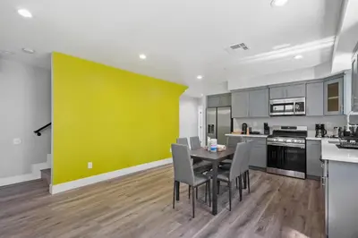 a kitchen with a table and chairs and a yellow wall at Modern Bedroom in Los Angeles