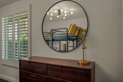 a mirror on a wall with a dresser and a chair at Los Angeles, CA Near Malibu - Pool in Los Angeles