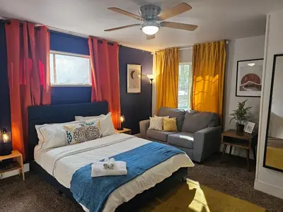 a bedroom with a bed and a couch at Forest Moon Cottage in Big Bear City Airport