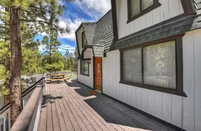 a house with a wooden walkway leading to the front door at The Mountain Treehouse, Jacuzzi Large Backyard! in Big Bear Lake