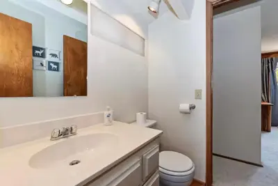 a bathroom with a sink and a toilet and a mirror at The Mountain Treehouse, Jacuzzi Large Backyard! in Big Bear Lake