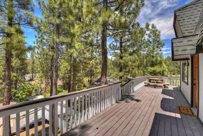 a wooden deck with a bench on a house at The Mountain Treehouse, Jacuzzi Large Backyard! in Big Bear Lake
