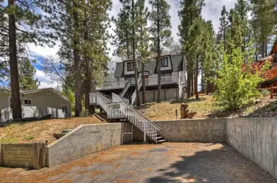 a large house with stairs in the woods at The Mountain Treehouse, Jacuzzi Large Backyard! in Big Bear Lake