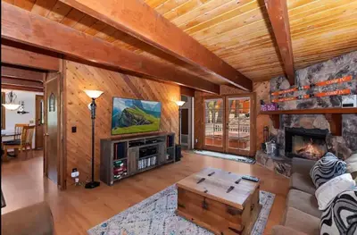 a living room with a fireplace and a tv at The Mountain Treehouse, Jacuzzi Large Backyard! in Big Bear Lake