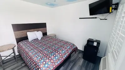 a bedroom with a bed and a flat screen tv at vogue motel in South Gate