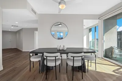 a dining room with a black table and chairs at Coastal Bliss - Luxe 2BR Retreat in MDR - Venice - SM in Los Angeles