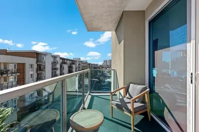 a balcony with a chair and a table at Coastal Bliss - Luxe 2BR Retreat in MDR - Venice - SM in Los Angeles