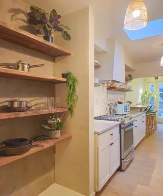 a kitchen with white counters and wooden shelves at Brimfield Stay in Los Angeles