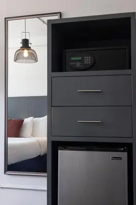 a bedroom with a dresser with a clock and a mirror at American Hotel in Los Angeles
