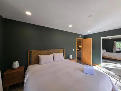 a bedroom with a large bed and a green wall at Modern Lagunita Cabin Near the Lake in Big Bear Lake