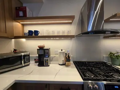 a kitchen with a stove top oven next to a microwave at Modern Lagunita Cabin Near the Lake in Big Bear Lake