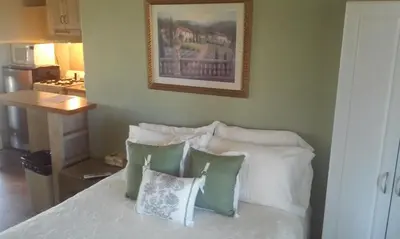 a bedroom with a bed with pillows and a picture on the wall at Hilltop Tavern and Inn in Apple Valley