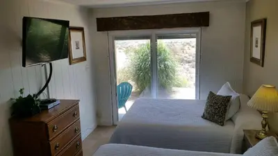 a bedroom with a bed and a sliding glass door at Hilltop Tavern and Inn in Apple Valley