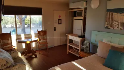a bedroom with a bed and a table and a kitchen at Hilltop Tavern and Inn in Apple Valley
