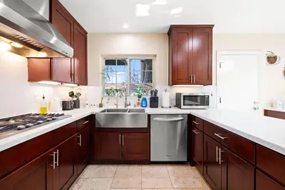 a kitchen with wooden cabinets and a stainless steel sink at Luxury Estate with Sparkling Pool & Elegant Amenities in Glendora
