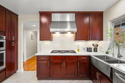 a kitchen with wooden cabinets and a stove top oven at Luxury Estate with Sparkling Pool & Elegant Amenities in Glendora