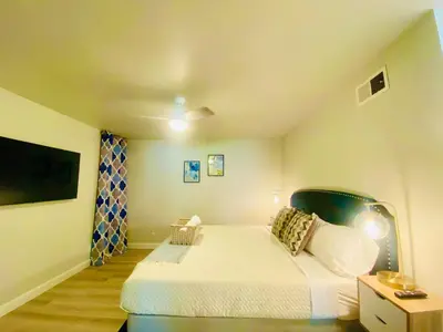 a small bedroom with a bed and a tv at Cheerful 4 bed, 2 bath with pool near Disneyland in Placentia