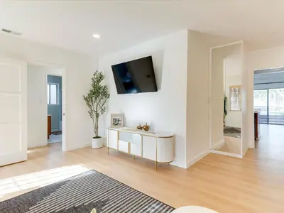 a white living room with a tv on a wall at Modern 4 bedroom in San Fernando in San Fernando