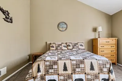 a bedroom with a bed and a clock on the wall at BIg Bear G5 Getaway in Big Bear Lake