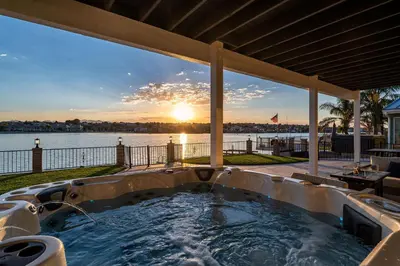 a hot tub on a patio with a view of the water at The Lakefront Oasis in Victorville