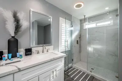 a bathroom with a sink and a shower and a mirror at The Lakefront Oasis in Victorville