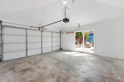 an empty garage with white doors and concrete floors at Cosy 3BD by Santa Monica - Beach & Airport 10 min away in Los Angeles