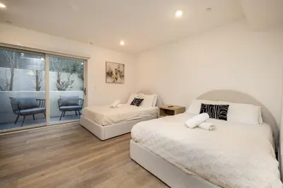 a bedroom with two beds and a balcony at Exquisite Haven with Patio Sleeps 4 in Los Angeles