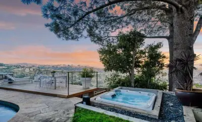 a hot tub on a patio with a tree at Secluded Luxury Hollywood Hills Retreat in Los Angeles