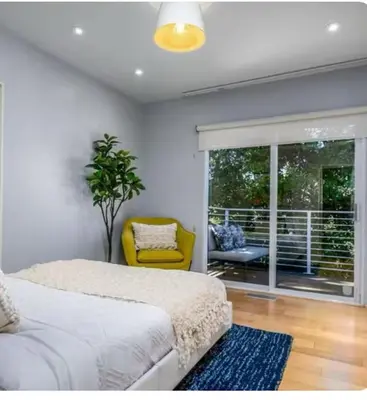 a bedroom with a bed and a yellow chair at Secluded Luxury Hollywood Hills Retreat in Los Angeles
