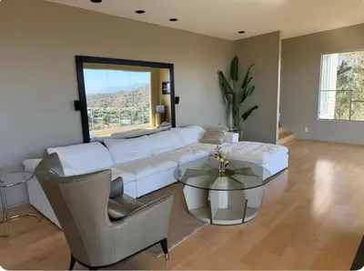a living room with a white couch and a glass table at Secluded Luxury Hollywood Hills Retreat in Los Angeles