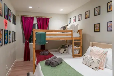 two bunk beds in a room with red curtains at Disneyland Retreat Fun Family Unit w Game Room, King Beds & EV Friendly - Sleeps up to 14 in Midway City