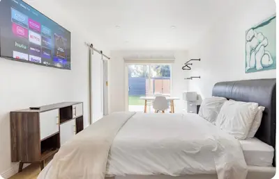 a bedroom with a bed and a tv and a table at Charming one bed one bath privet studio in Tarzana