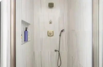 a bathroom with a shower with a blue bottle on the wall at Charming one bed one bath privet studio in Tarzana