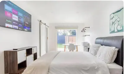 a bedroom with a bed and a tv and a table at Charming one bed one bath privet studio in Tarzana