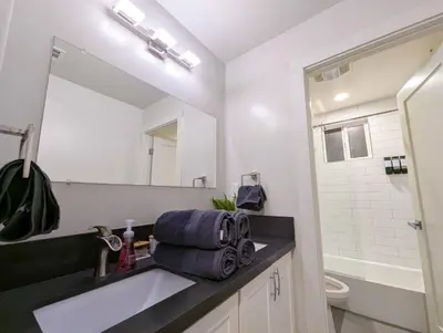 a bathroom with a sink and a toilet and a mirror at Central North Hollywood Home in Los Angeles