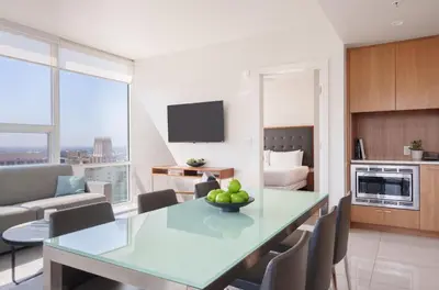 a kitchen and living room with a table with fruit on it at Level Los Angeles - Downtown South Olive in Los Angeles