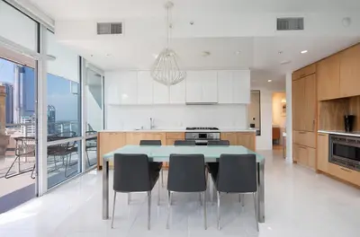 a kitchen with a blue table and chairs in a kitchen at Level Los Angeles - Downtown South Olive in Los Angeles