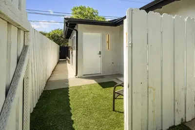 a fence with a white door in a yard at Cute House in West Valley Area Heliport