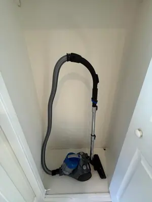 a vacuum cleaner sitting in the corner of a room at Cute House in West Valley Area Heliport