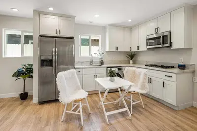 a kitchen with white cabinets and a stainless steel refrigerator at Cute House in West Valley Area Heliport