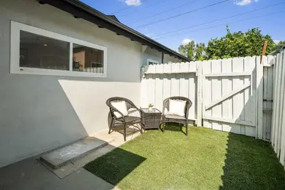 two chairs and a table next to a white fence at Cute House in West Valley Area Heliport