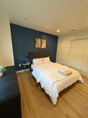 a bedroom with a large bed and a blue wall at New Luxe 3B 3Bath Townhouse in Sherman Oaks
