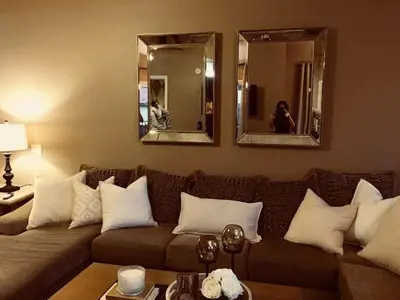 a living room with a couch and two mirrors at Beautiful Mountain Home in Tehachapi