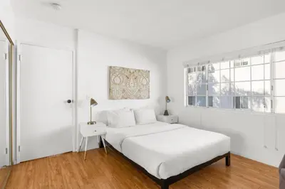 a white bedroom with a bed and a window at Modern Furnished 2 Bedroom in West LA in Los Angeles