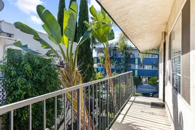 a balcony with a fence and a palm tree at Modern Furnished 2 Bedroom in West LA in Los Angeles