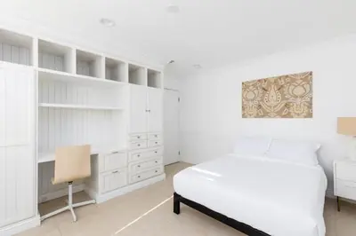 a white bedroom with a bed and a desk at 3 bedroom near Culver City-Palms in Los Angeles